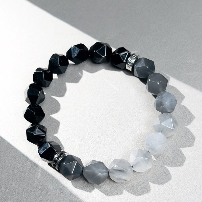 Close-up of Cloud Crystal’s ethereal patterns and Black Agate’s smooth surface for anxiety relief and energy stabilization