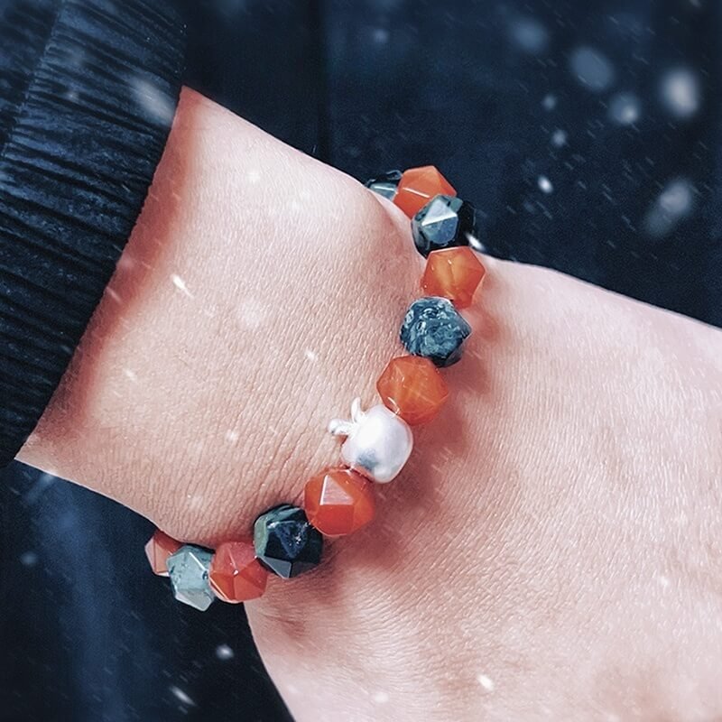 Couple wearing Christmas red agate bracelets for shared Root Chakra vitality and holiday love
