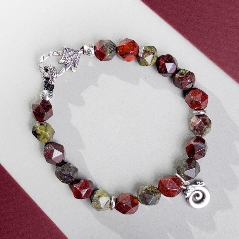 Close-up of Dragon Blood Stone beads with fiery red texture for powerful protection and Root Chakra stabilization