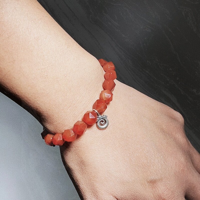 Woman wearing luxury Red Agate bracelet in office for confidence and emotional harmony
