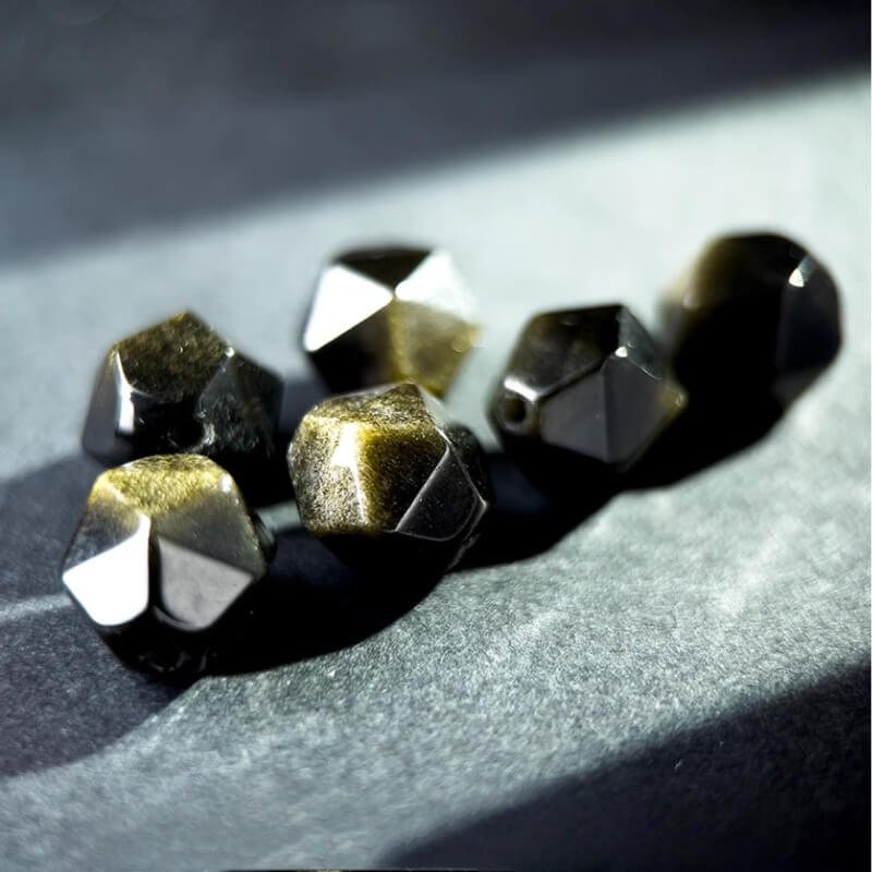 Close-up of 10mm Gold Sheen Obsidian beads showcasing golden metallic sheen – symbolizes wealth, luck, and negative energy dispelling.