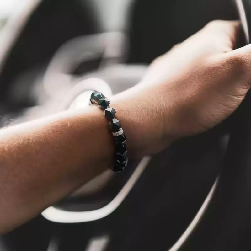 Man in business suit wearing Black Agate bracelet for Root Chakra confidence and stress protection at work