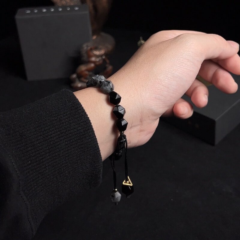 Man in business suit wearing Black Amphibole bracelet for Root Chakra stability and work stress relief
