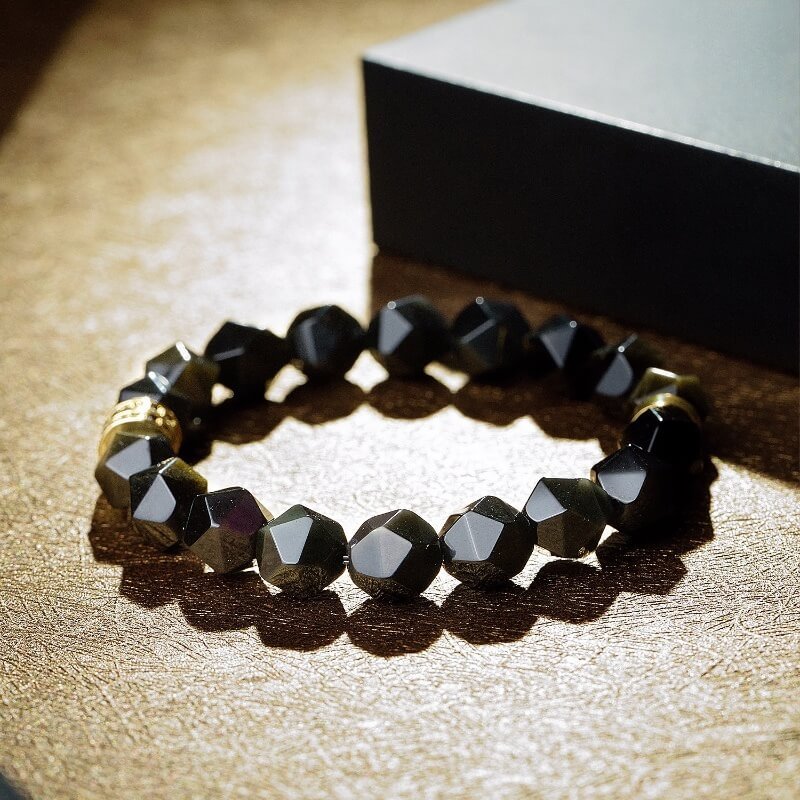 Detail of premium metal accessories and faceted cut for Gold Sheen Obsidian bracelet’s luxury appeal