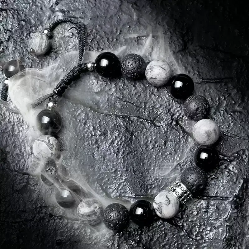 Close-up of Obsidian (matte black), Picasso Stone (abstract patterns), and Volcanic Stone (ash textures) – symbolizes protection, inspiration, and earthly vitality.