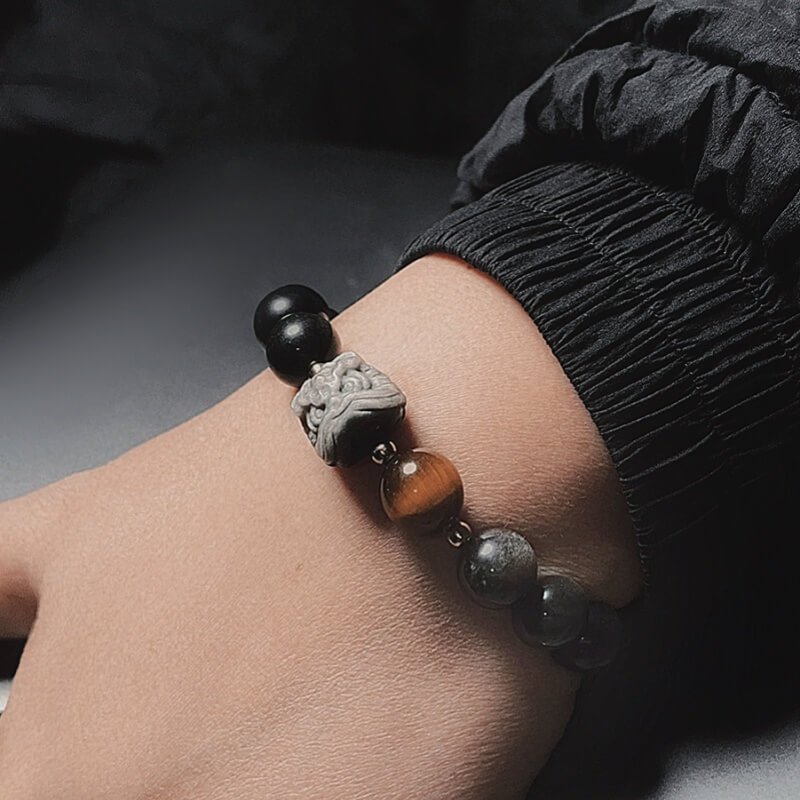 Close-up of Obsidian + Tiger’s Eye beads (10mm) – absorbs negative energy and boosts courage for Root Chakra stability.