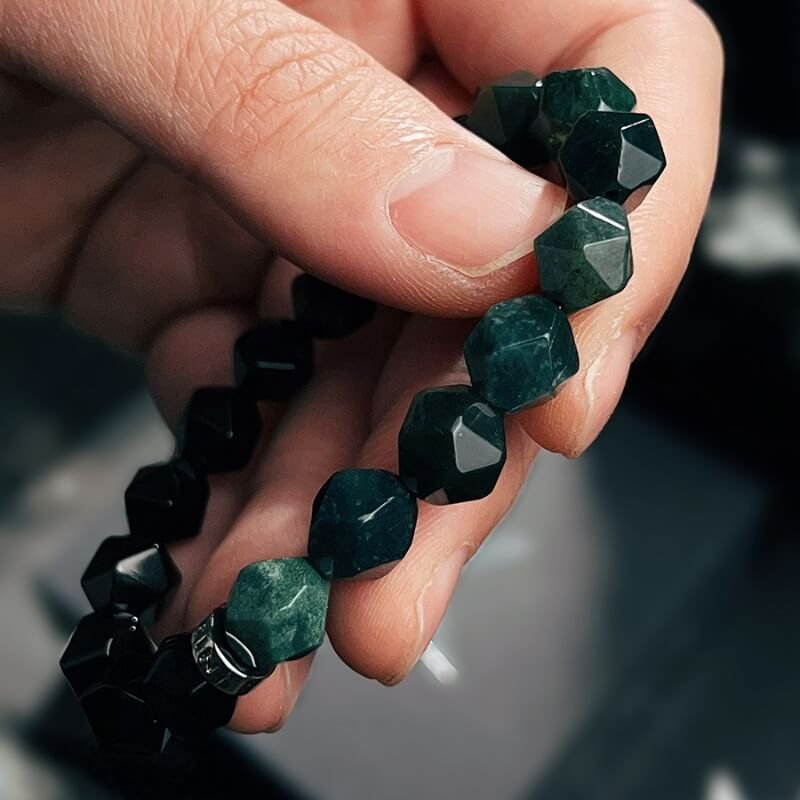Person meditating in nature with Dendritic Agate bracelet for Heart Chakra peace and Root Chakra stability