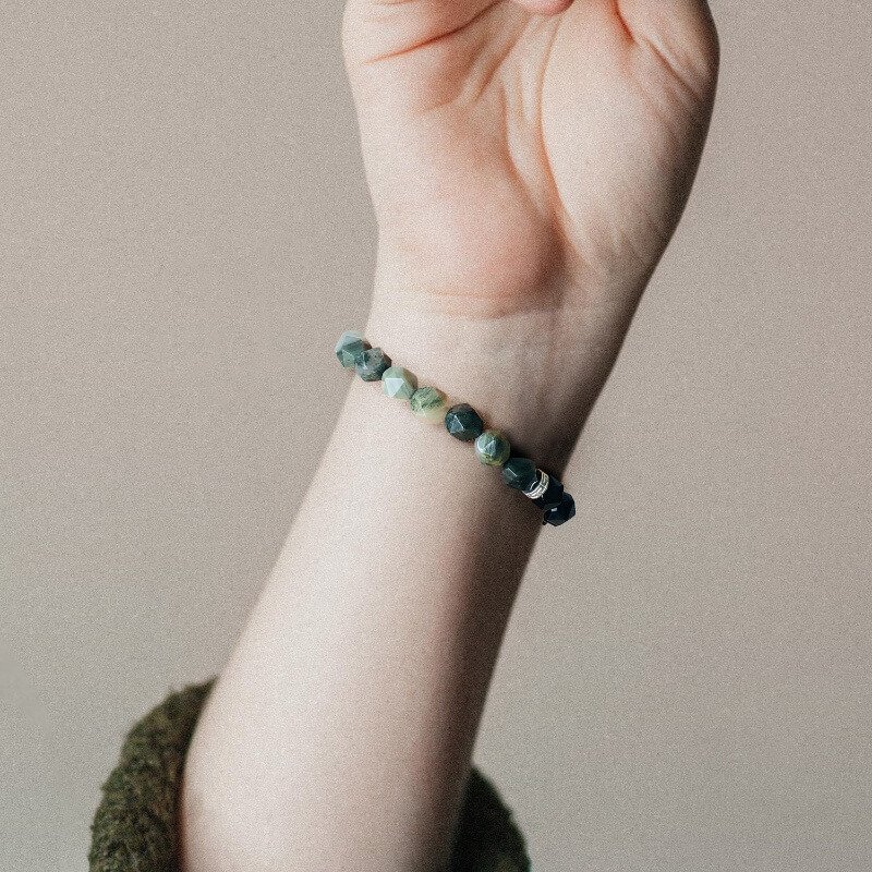 Woman in business casual wearing Quezai Stone bracelet for Heart Chakra calm and Root Chakra focus during meetings