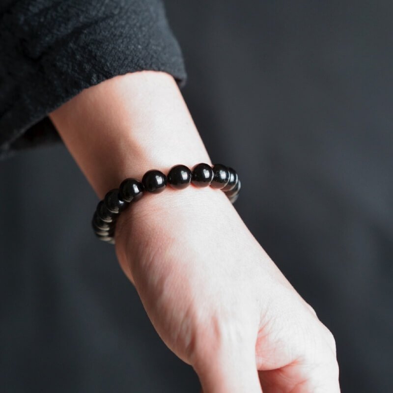 Person meditating with Terahertz bracelet for full chakra purification and Black Agate grounding